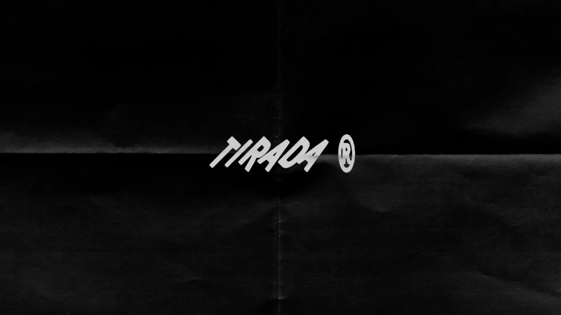 Logo manuscrito de Tirada sobre papel negro doblado