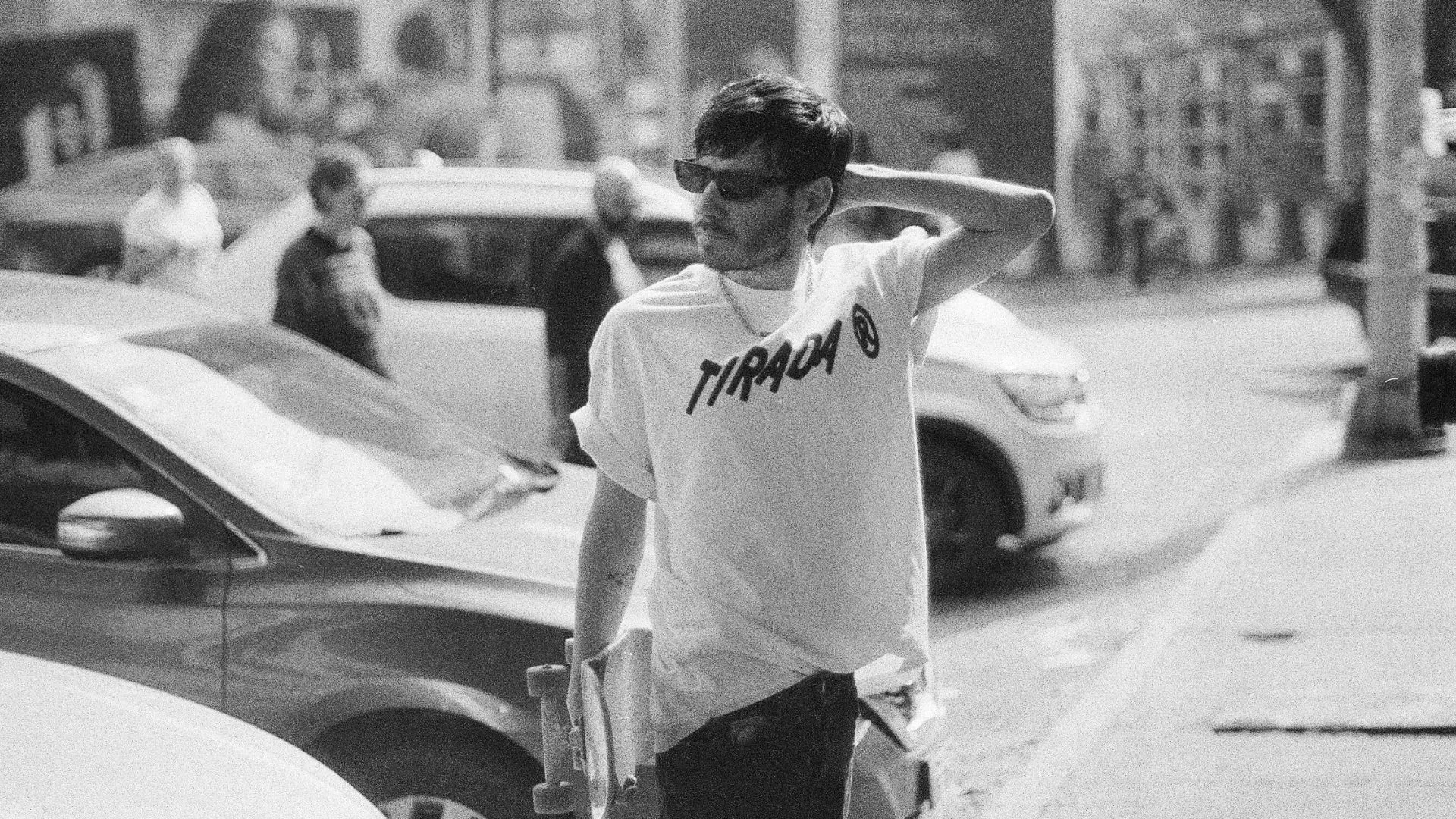 Chico con patineta en la calle, blanco y negro